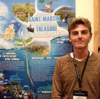 Julien Chalifour at the GCFI conference, in front of the poster featuring the 818 species in Saint-Martin